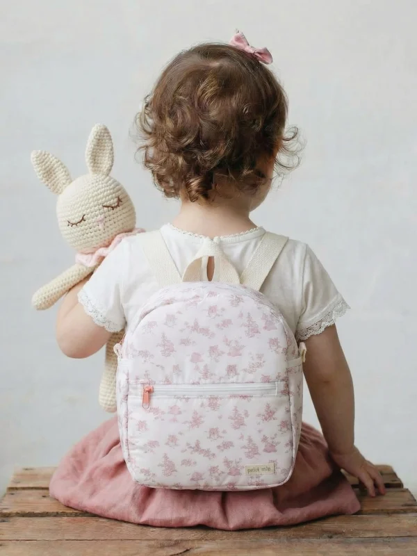 niña pequeña con mochila infantil impermeable rosa para guardería con estampado delicado
