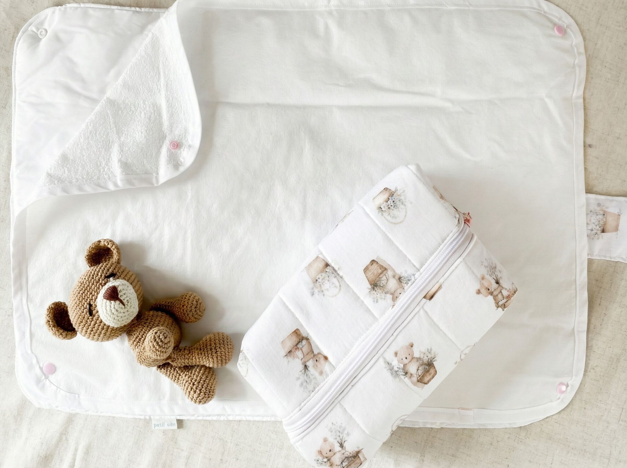 "Cambiador portátil blanco y neceser con estampa de ositos de Petit Miu para una organización maternal con estilo."