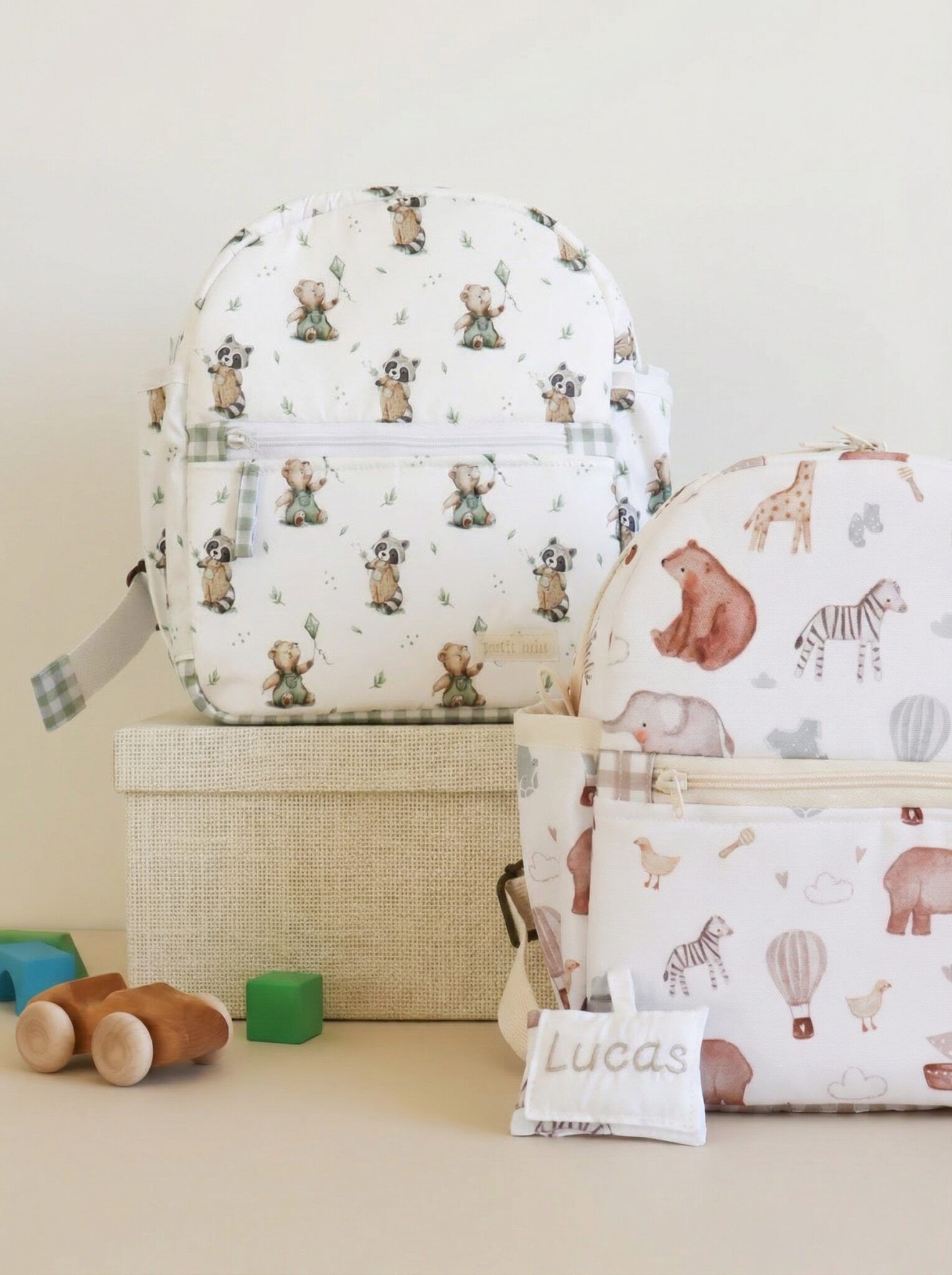 Mochila guardería personalizada con diseño de animalitos, con nombre bordado y bolsillos, acompañada de mochila pequeña y juguetes.