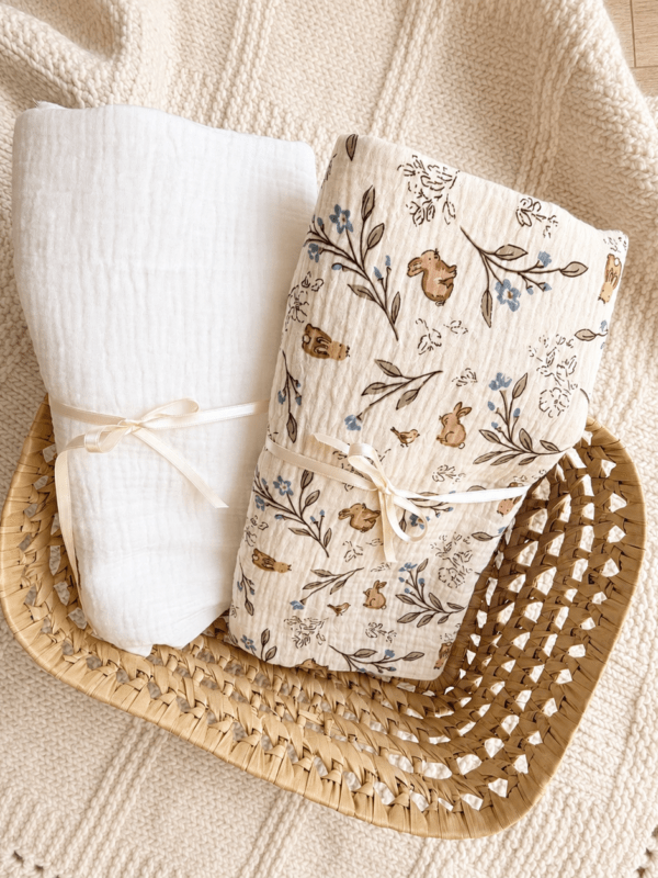 Dos muselinas para bebé de algodón orgánico, una blanca y otra con estampado de conejitos y flores, hechas a mano.